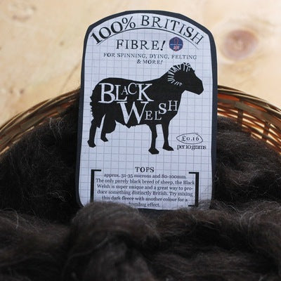 a basket with black welsh fibre a tag on top that says 100% british fibre for spinning, dying, felting & more