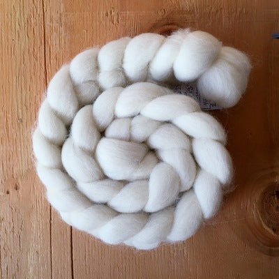 a braid of 100% shetland white british wool on a wooden background
