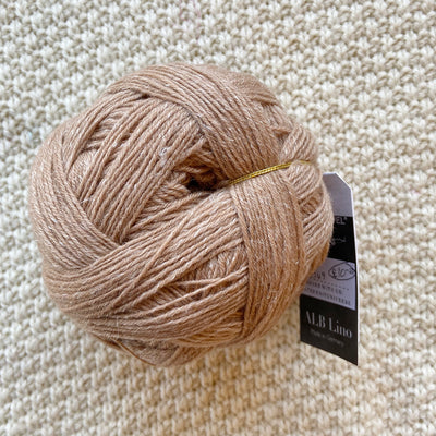 light brown alb lino 100g sock yarn wool and linen on a crocheted white blanket