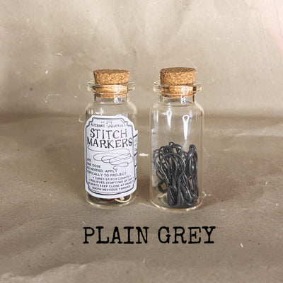 clear small cork bottle with gray stitch markers in