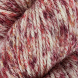 a close up of red pink white orange aran weight skein machine washable for knitting crocheting and weaving