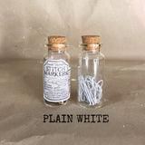 clear small cork bottle with white stitch markers in