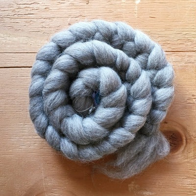 a braid of 100% shetland grey wool on a wooden background