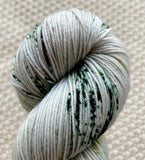 a close up of mint green fingering weight yarn in a 100g skein