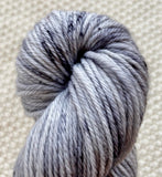 a close up of dark and light grey dk double knit weight yarn in a 100g skein