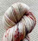 a close up of white red black dk double knit yarn in a 100g skein