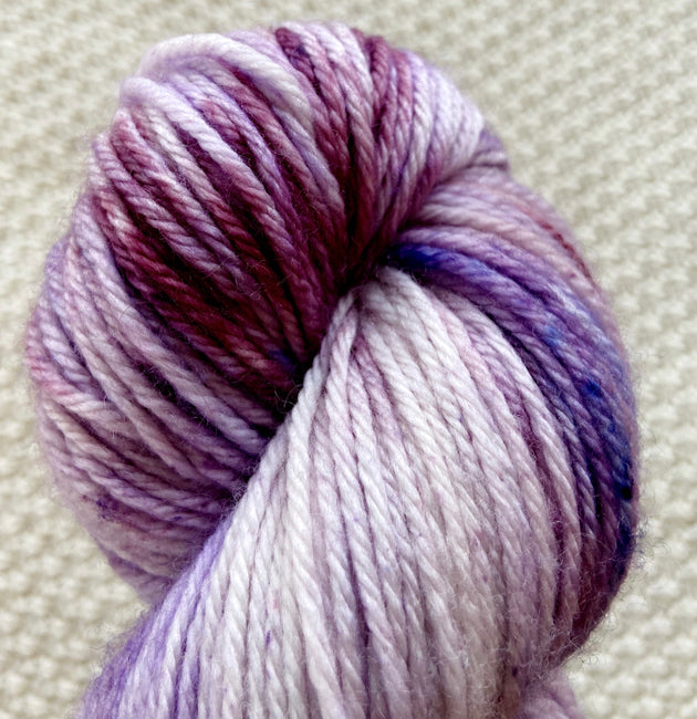 a close up of lilac purple dk double knit weight yarn in a 100g skein