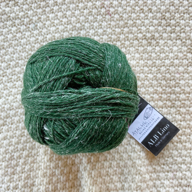 green alb lino 100g sock yarn wool and linen on a crocheted white blanket