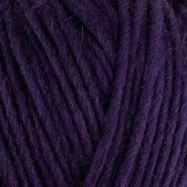 a close up of british bluefaced kerry hill fleece in dark purple chunky weight yarn for knitting weaving or crochet