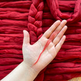 red eco nylon biodegradable spinning fibre braid white woman holding a bit of fibre in her hand 