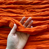 a white woman holding the orange eco nylon biodegradable fibre 