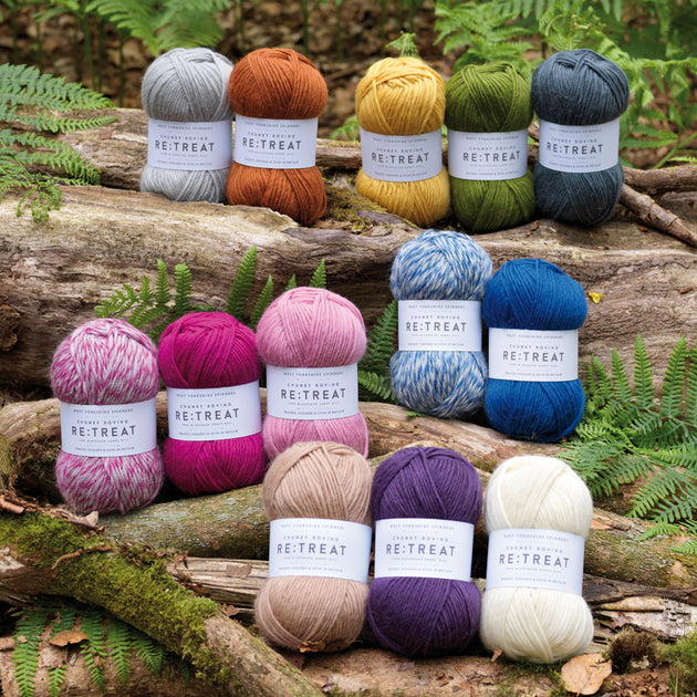 loads of retreat yarns on top of logs with green plants 