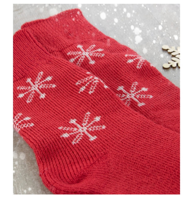 a close up of west yorkshire spinners christmas socks pair of red socks with white snowflakes 
