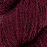close up of burgundy red aran weight skein machine washable for knitting crocheting and weaving