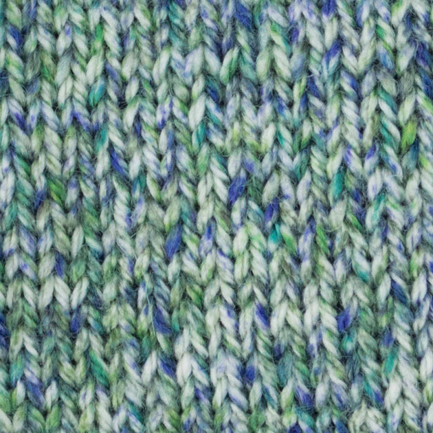 a close up of a knitted swatch green blue white aran weight skein machine washable for knitting crocheting and weaving