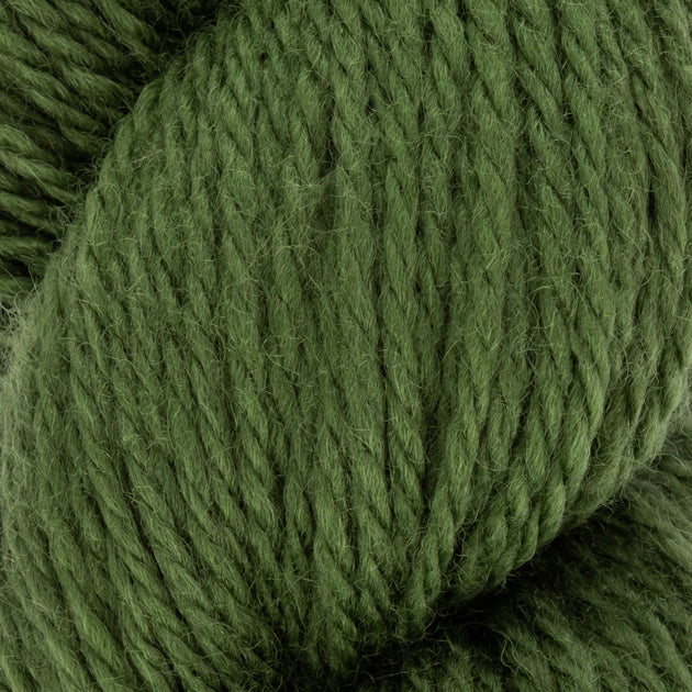 close up of green aran weight skein machine washable for knitting crocheting and weaving 