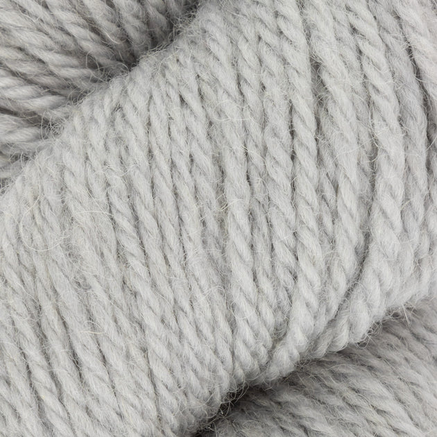 close up of white aran weight skein machine washable for knitting crocheting and weaving 