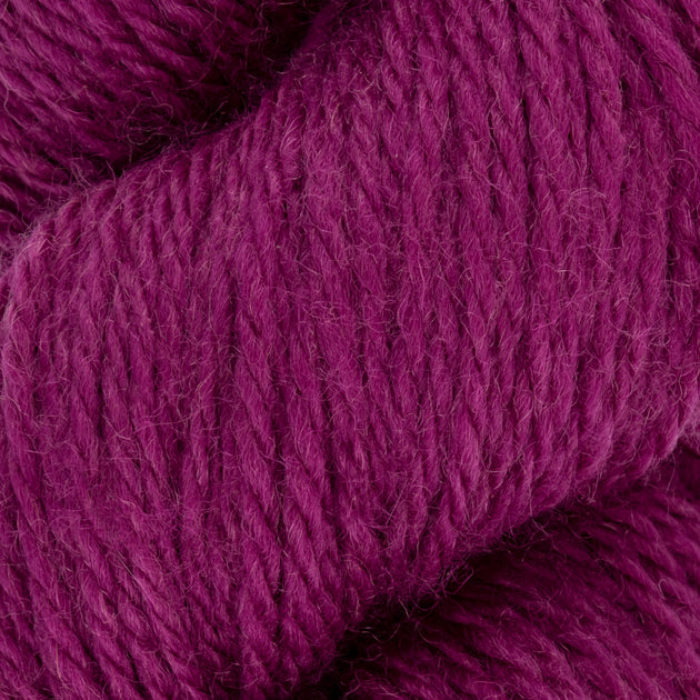 close up of purple pink aran weight skein machine washable for knitting crocheting and weaving