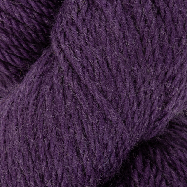 a close up of dark purple aran weight skein machine washable for knitting crocheting and weaving
