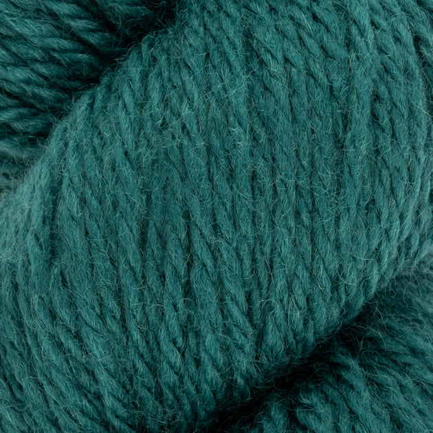 a close up of teal green blue aran weight skein machine washable for knitting crocheting and weaving