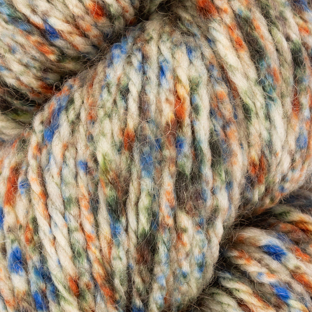 close up of orange blue green white aran weight skein machine washable for knitting crocheting and weaving