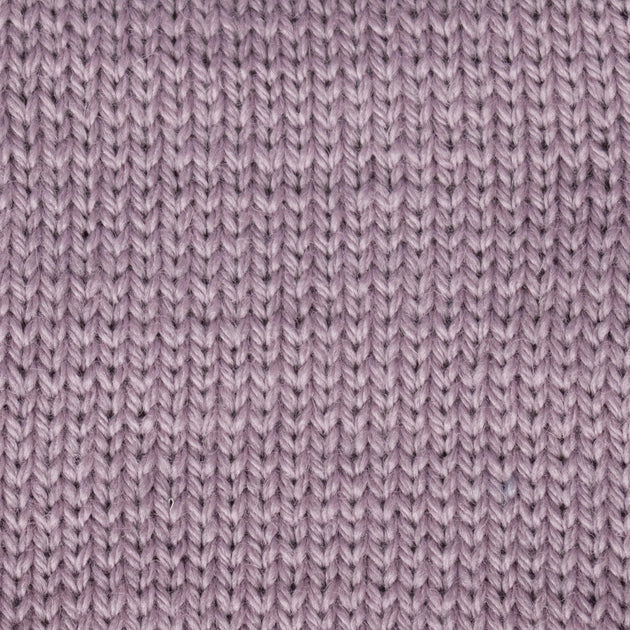 a close up of a knitted swatch lilac purple pink aran weight skein machine washable for knitting crocheting and weaving