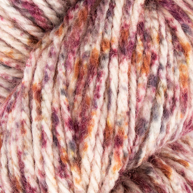close up of red purple orange white aran weight skein machine washable for knitting crocheting and weaving 